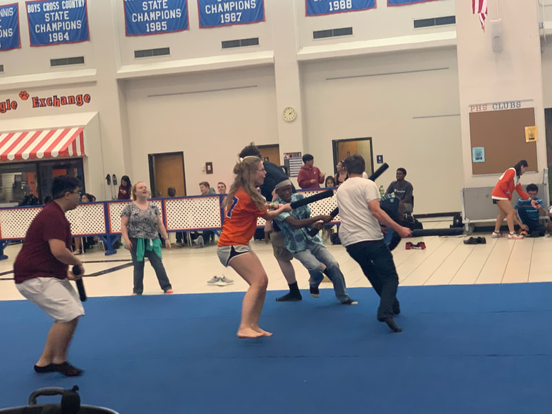 Male and Female students participate in gladiator fights in a cafeteria. 